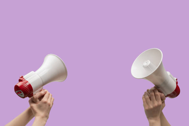 istock Megaphone in woman hands on a purple background. 1411295580