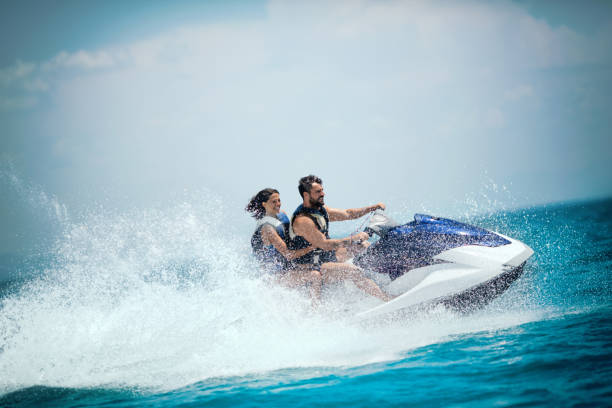 Jet ski adventure. Young couple jet skiing on the open sea. They are smiling and enjoying summer sport on water. jet boat stock pictures, royalty-free photos & images