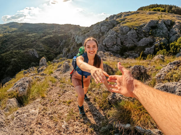 istock Boyfriend Helping Girlfriend Climb Up The Mountain 1411296813