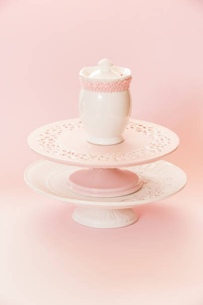 istock Empty white and pink cake stands and ceramic sugar pot, sugar serving bowl on top. Pink background with copy space, selective focus 1411296991