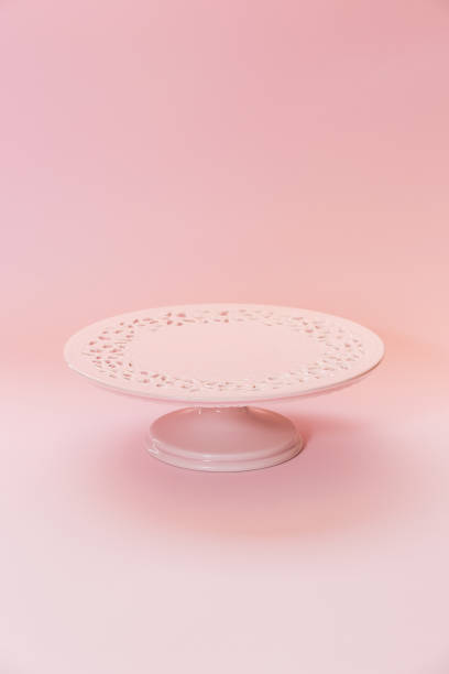 istock Small ceramic empty pink pedestal cake stand on a pastel pink table. Selective focus, copy space 1411296996