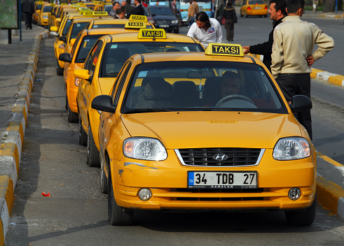 Istanbul, Turkey / Türkiye: taxi rack in Uskudar square - row of taxis with some drivers outside - Üsküdar District - in Turkish the spelling 'Taksi' is used.
