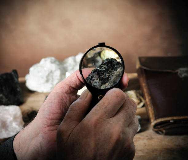 istock Geologist examining a mineral sample under a magnifying glass 1411300845