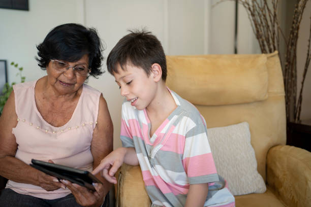 istock Grandmother and grandson using tablet at home 1411304459