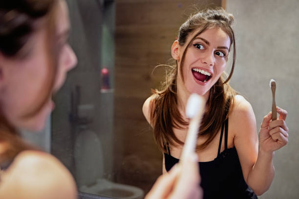 istock Young woman is brushing her teeth in a bathroom 1411305382