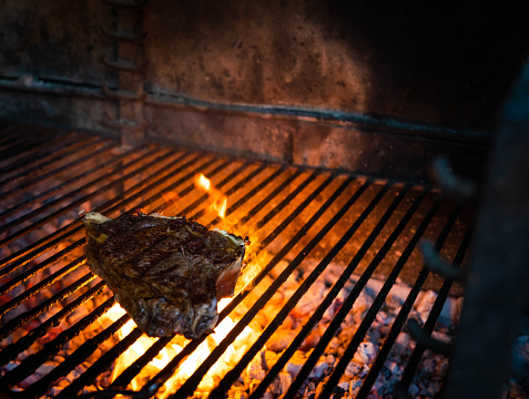 Raw Spanish beef steak Chuleton on charcoal grill