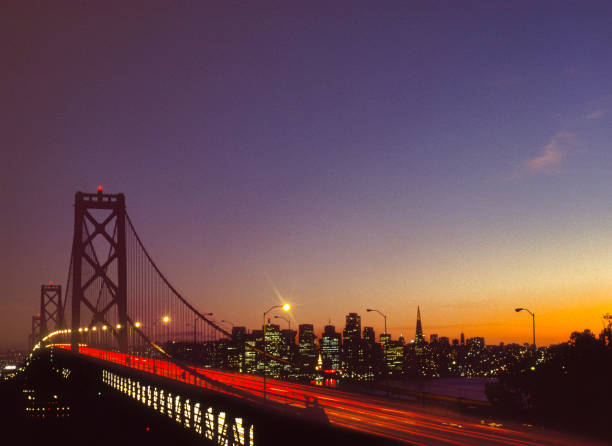 Long exposure of San Francisco Bay Bridge with cityscape at sunset in background.Taken from Treasure Island, San Francisco, California, USA