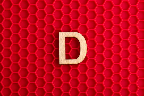istock Alphabet letter D - White piece on silicone background with red hexagons 1411315751