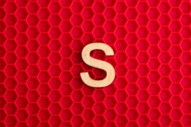 istock Capital letter S - White piece on silicone background with red hexagons 1411316441