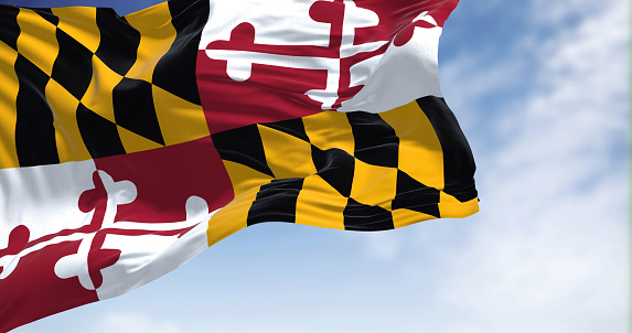 The US state flag of Maryland waving in the wind on a clear day. Maryland is a state in the Mid-Atlantic region of the United States. Democracy and independence.