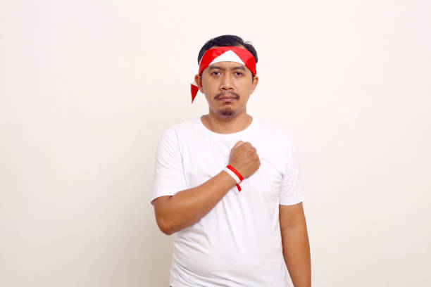 istock Asian man standing with respect gesture. Indonesian independence day concept. Isolated on white 1411318902