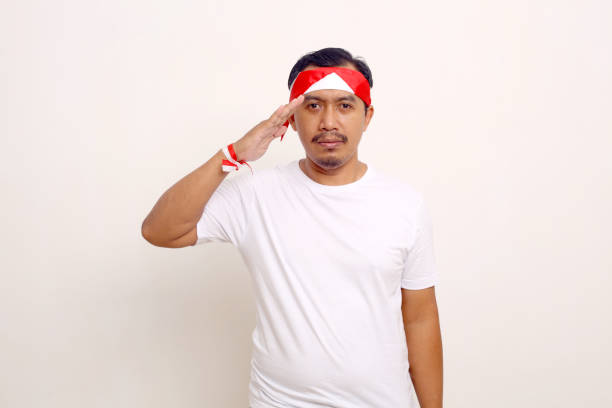 istock Asian man standing with respect gesture. Indonesian independence day concept. Isolated on white 1411318907
