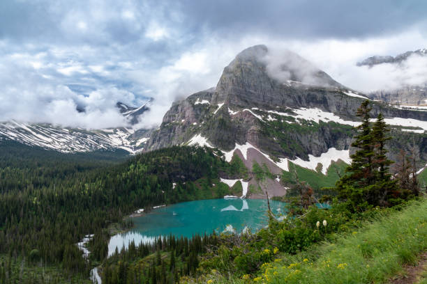 grinnell lake along the grinnell glacier hiking trail in glacier national park montana on an overcast day - mount grinnel imagens e fotografias de stock