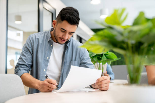 Business man working at the office and signing a contract stock photo