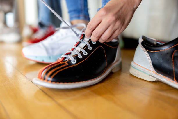 Close-up on a man tying his bowling shoes at the alley - sports and recreation concepts