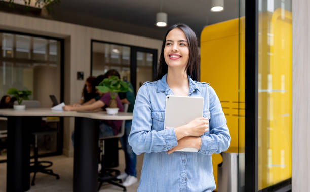 istock Business woman holding a tablet computer at a coworking office 1411322827