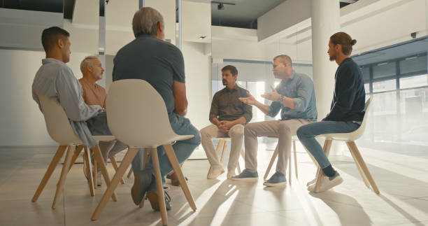 istock Men in a group therapy session with with a therapist. Grieving widowers getting advice from a grief counsellor, speaking in a trust circle with friends. AA meeting for men only discussing challenges 1411325448