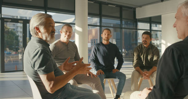istock A psychology support group speaking about their emotions and mental health problems. Group of men sitting in a circle during a therapy session. Recovering addicts talk in a meeting at a rehab center 1411325470