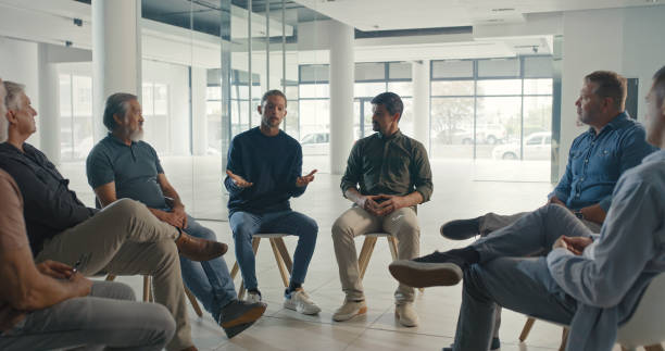 istock A support group of men talking and sitting in a circle during a therapy session in a workshop or corporate office. Team of colleagues discussing feelings and emotions in a group psychology meeting 1411325483