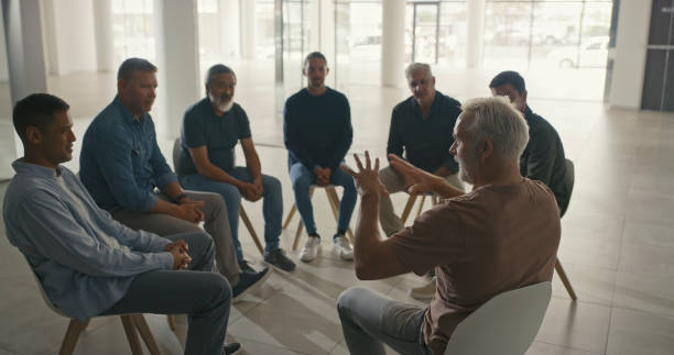 istock Mature men in a therapy session with with a therapist. Grieving widowers getting advice from a grief counsellor, speaking in a trust circle with friends. AA meeting for men only discussing struggles 1411325519