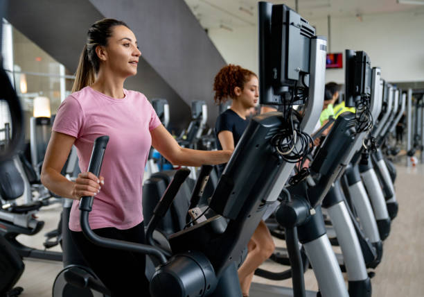 istock Women exercising at the gym using elliptical trainers 1411330428