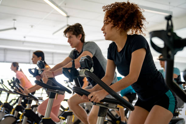 grupo de personas en forma que trabajan en una clase de spinning - ejercicio cardiovascular fotografías e imágenes de stock