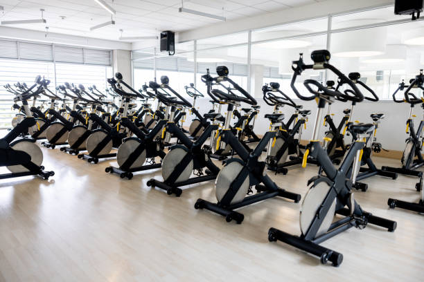 Group of bicycles in a exercising classroom at the gym Group of bicycles in an empty exercising classroom at the gym - sports equipment concepts spin bike stock pictures, royalty-free photos & images