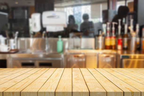 istock Empty wood table top with coffee shop cafe restaurant counter blur background 1411336779
