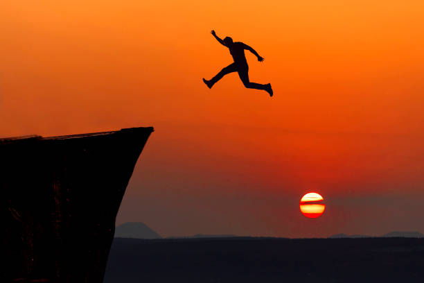 istock Go ahead and continuously improvement concept, silhouette man jump on a cliff 1411336844
