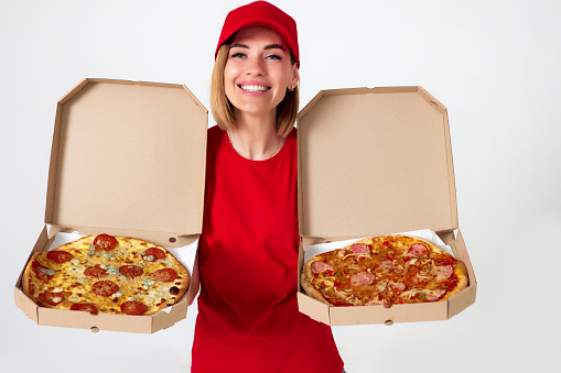 pizza delivery girl showing pizza inside boxes on white background. choose according to your taste