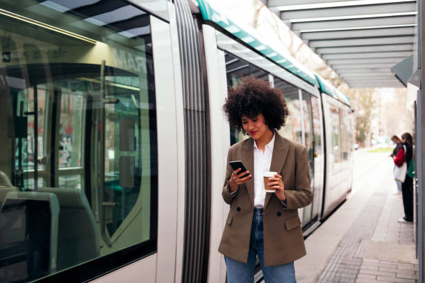 istock woman checking phone while waiting for the tram 1411337467