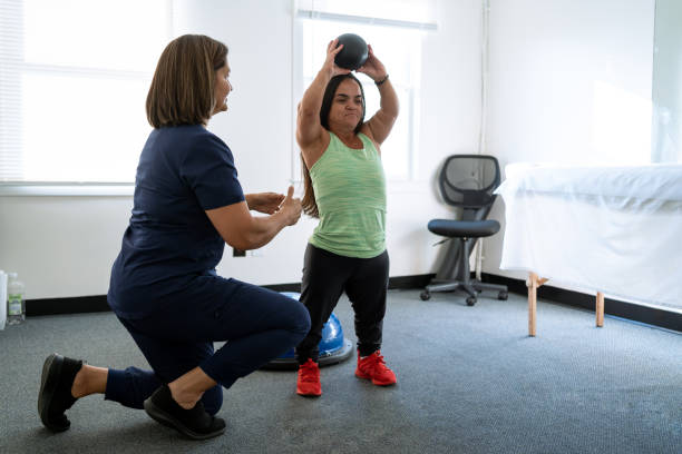 Physiotherapist performing techniques with a female client with dwarfism Physiotherapist performing techniques with a female client with dwarfism short stature stock pictures, royalty-free photos & images