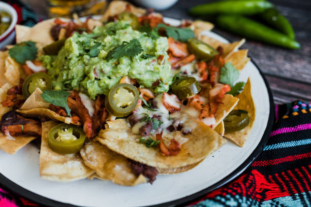 mexikanische nachos-chips mit amerikanischem käse und avocado, traditionelles essen in mexiko lateinamerika - guacamole avocado mexican culture food stock-fotos und bilder