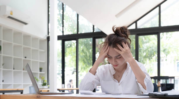 istock Tired business woman with headache at office, feeling sick at work. 1411341291
