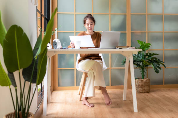 istock Young people work from home checking report for presentation with laptop morning relax at home. Asia woman meeting conference connect online with office. 1411342158