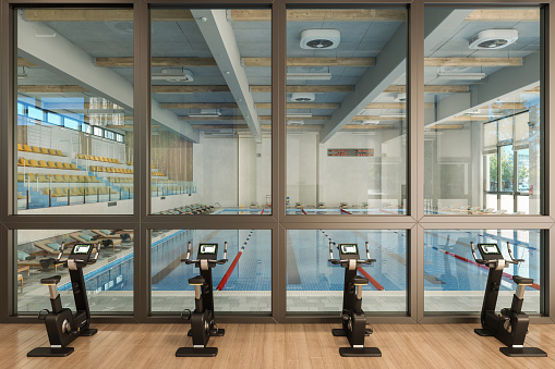 Interior del gimnasio con bicicletas estáticas y piscina photo