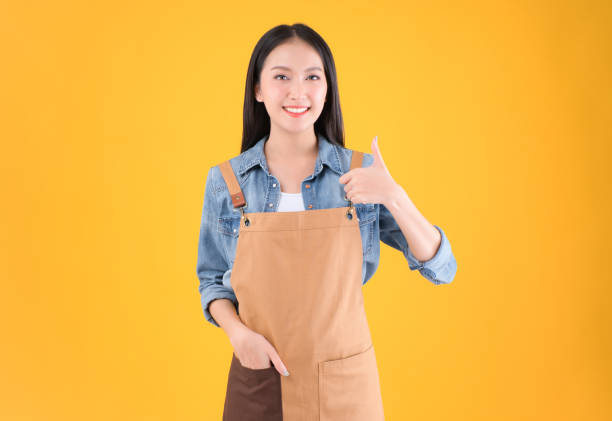pretty asian female smile coffee freelancer own coffee bar shop hold coffee paper cup and payment with a credit card through terminal money swiping a credit card in her own shop yellow background. bonita asiática sonrisa de café freelance propia cafetería tienda de café sostener taza de papel de café y pago con una tarjeta de crédito a través de la terminal de dinero deslizando una tarjeta de crédito en su propia tienda fondo amarillo.