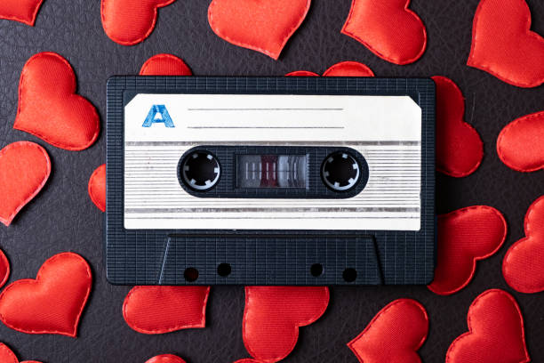 Audio Cassette with a Hearts Old Audio Tape Cassette on a Scattered Red Hearts closeup mix tape heart stock pictures, royalty-free photos & images