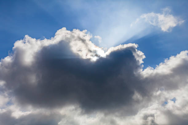 istock Beautiful sky with white clouds and sunlight shining through the clouds 1411351951