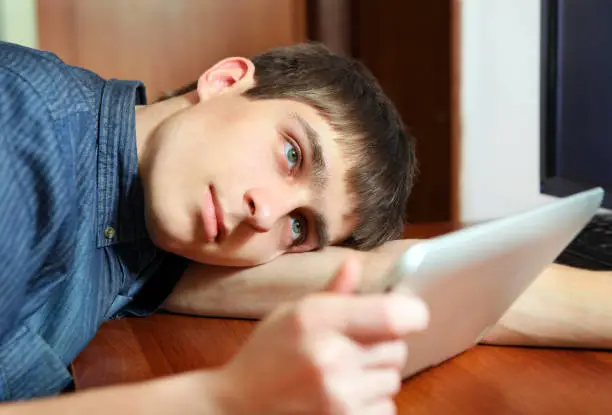 Tired Young Man with Tablet Computer at the Home