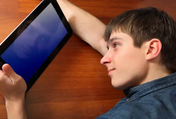 Tired Young Man with Tablet Computer at the Home