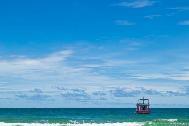 Fishing boat on the turquoise sea with bright blue sky.
