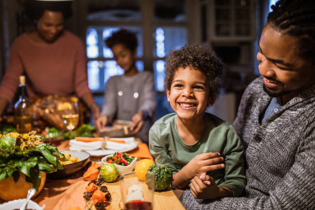 istock Cheerful black boy with his father at dining table. 1411355321