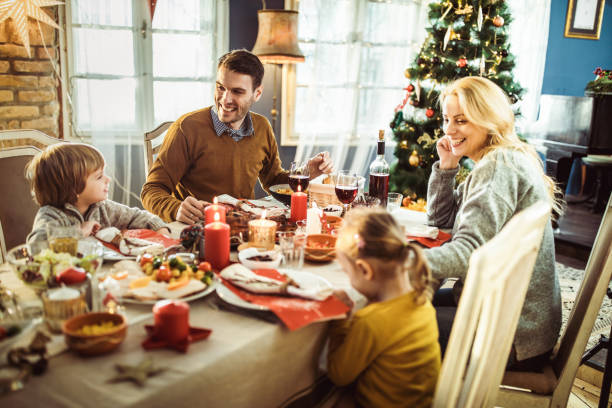 istock Happy family enjoying in conversation during Christmas dinner at dining table. 1411355624