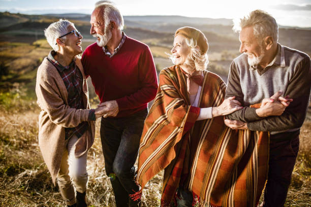 istock Happy mature couples talking while walking on the hill in autumn day. 1411355971