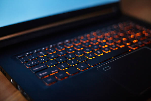 istock Laptop keyboard with orange neon illumination, backlit keyboard. 1411358511