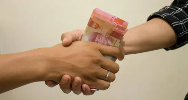 Photo of hand is giving bribe
