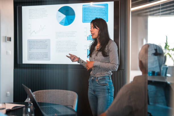 istock Side Shot of Female CEO Explaining Ideas with Graphs at the Office 1411362474