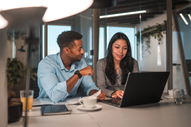 istock Smart Male and Female Coworkers Using Laptop at Office 1411362714