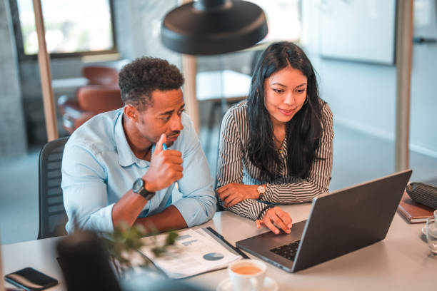 istock Mixed Race Man and Latin Woman Looking at Laptop Screen During Work 1411362731